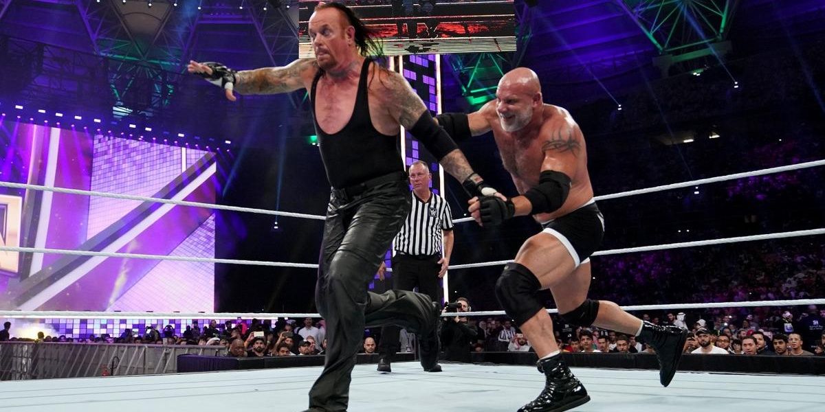 Goldberg whips The Undertaker into the ropes