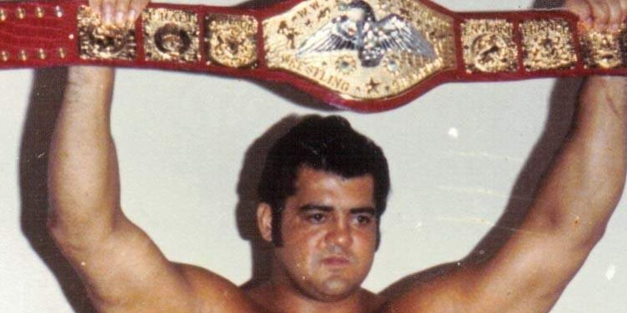 Pedro Morales posing for a picture while holding the main championship.