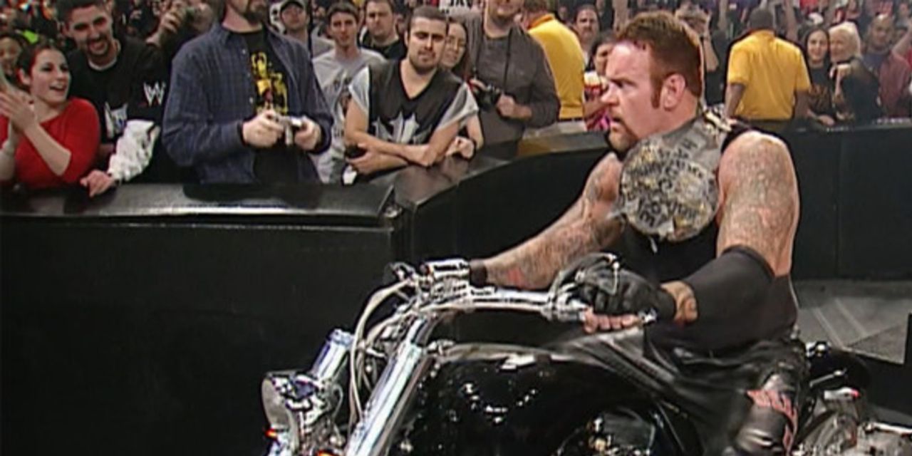 Undertaker riding a motorcycle with the Hardcore Title on his shoulder