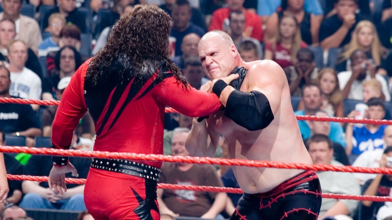 WWE Imposter Kane With His Hand Around The Neck Of The Real Kane In The Ring