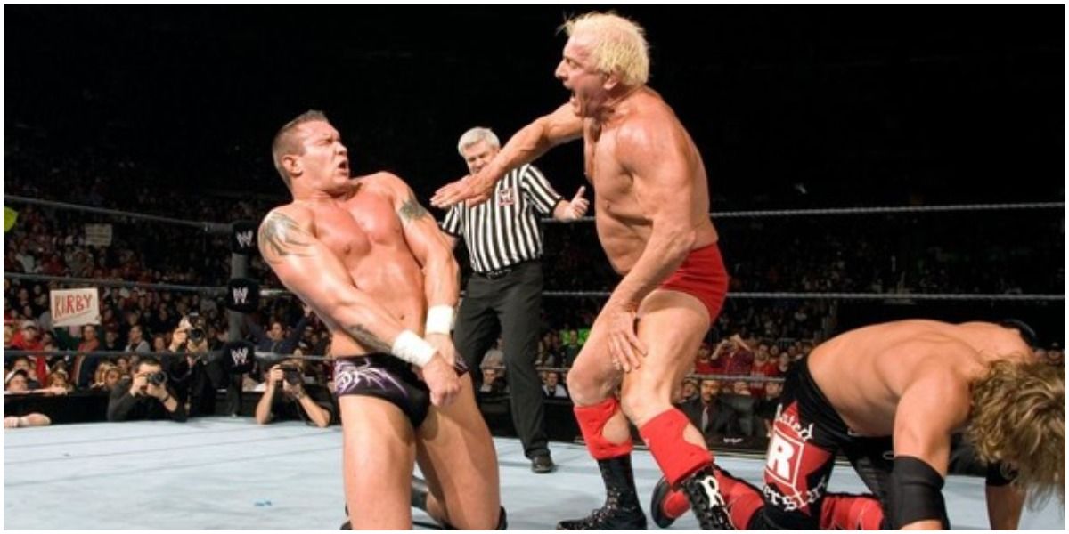 WWE Ric Flair Chopping Ric Flair Beside A Hunched-Over Edge