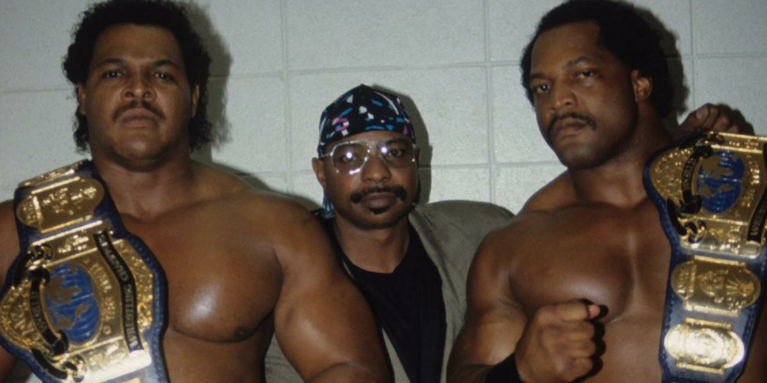 Doom and Teddy Long posing backstage with the NWA World Tag Team Championships.