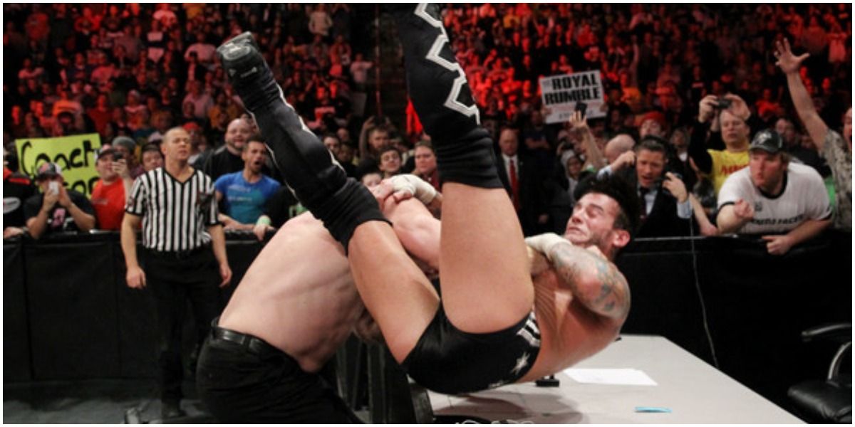 Kane putting CM Punk through the announcement table