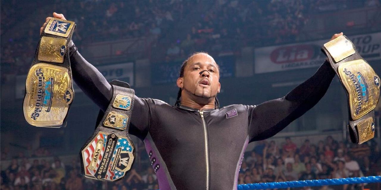 MVP posing in the ring with multiple titles
