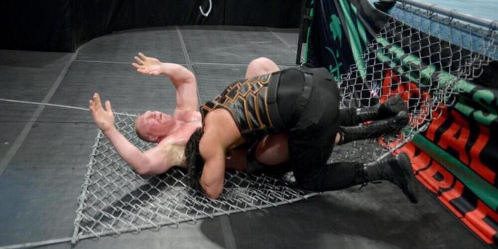 Roman Reigns spears Brock Lesnar through the cage