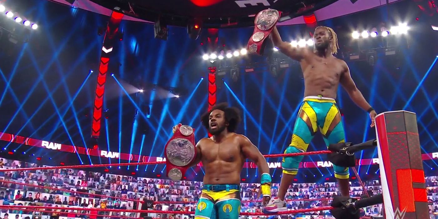 The New Day holding up the WWE Raw tag team titles.