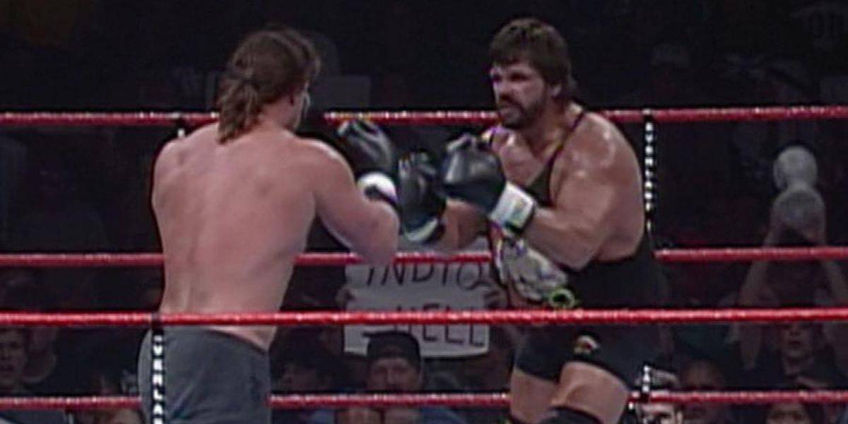 Bart Gunn and Steve Williams stand in the middle of the ring for a Boxing Match, with both having their gloves at the ready to start striking.