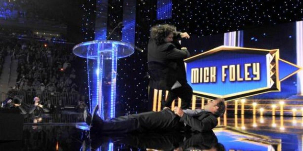 Mick Foley drops an elbow on Chris Jericho at the Hall Of Fame ceremony 