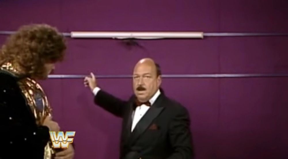 Mean Gene Okerlund inspects a fallen sign with Rick Rude at SummerSlam 1989