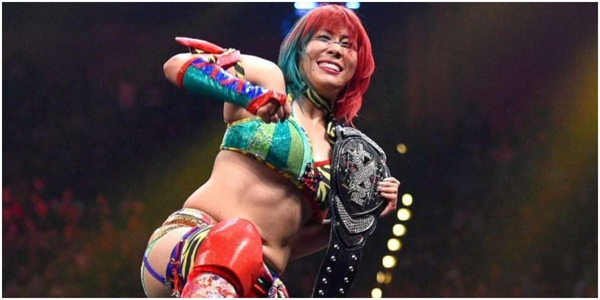Asuka holding the NXT Women's Championship on her shoulder