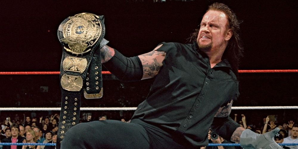 The Undertaker holding the winged eagle WWE Championship. 