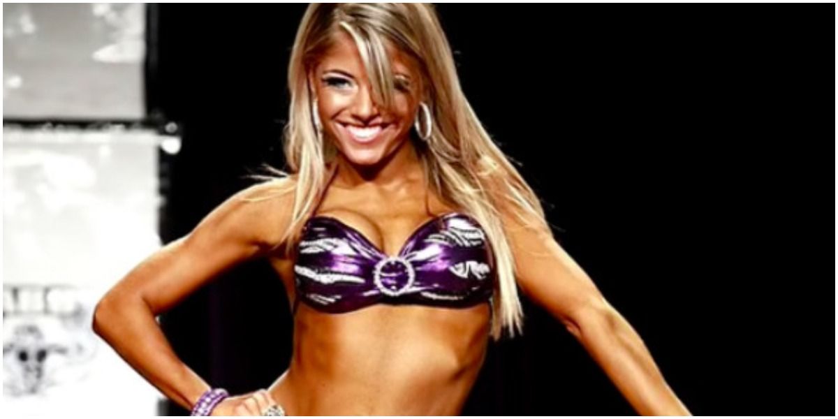 Alexa Bliss posing for a picture at bodybuilding tournament