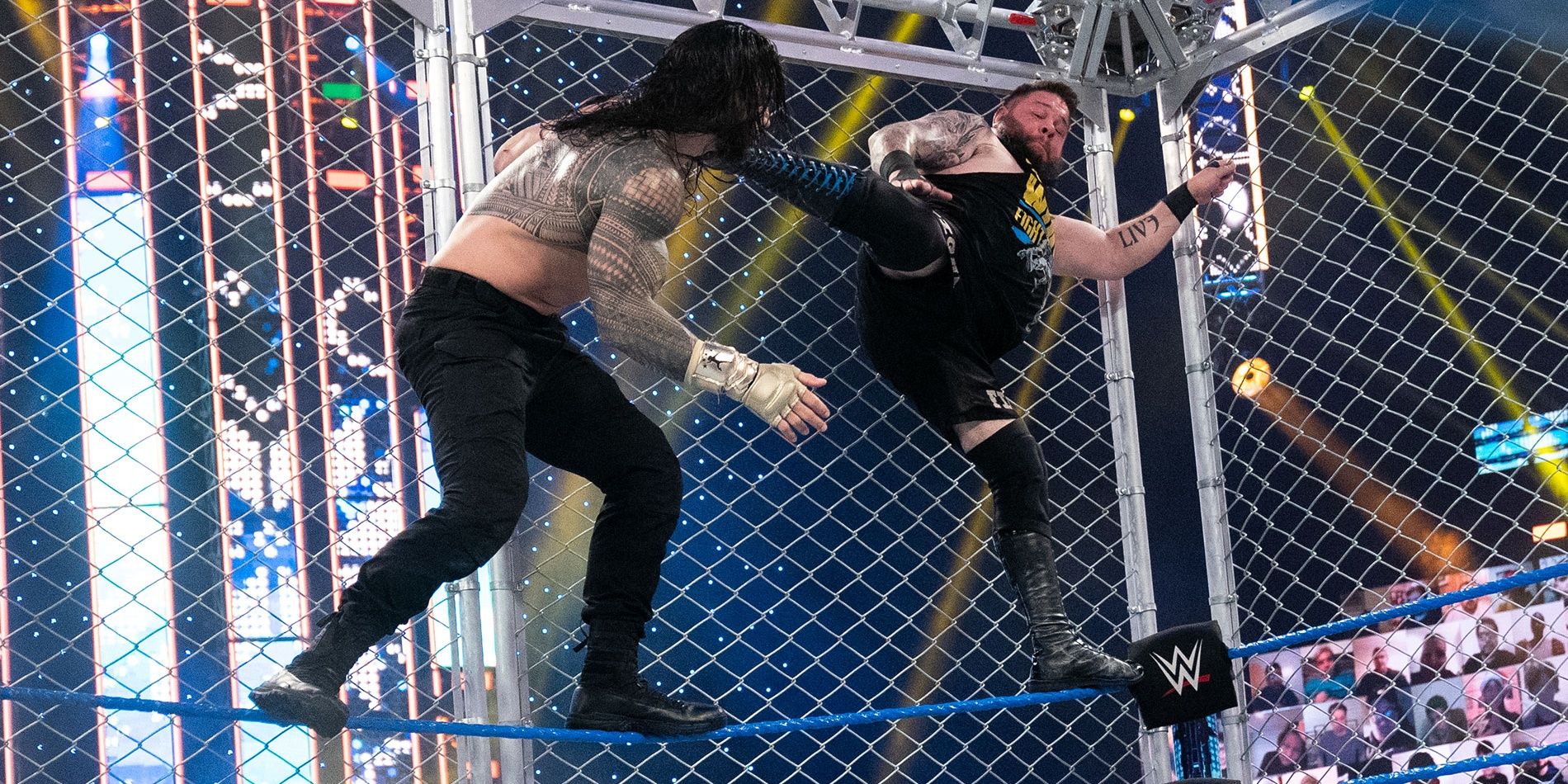 Kevin Owens and Roman Reigns inside a steel cage Cropped
