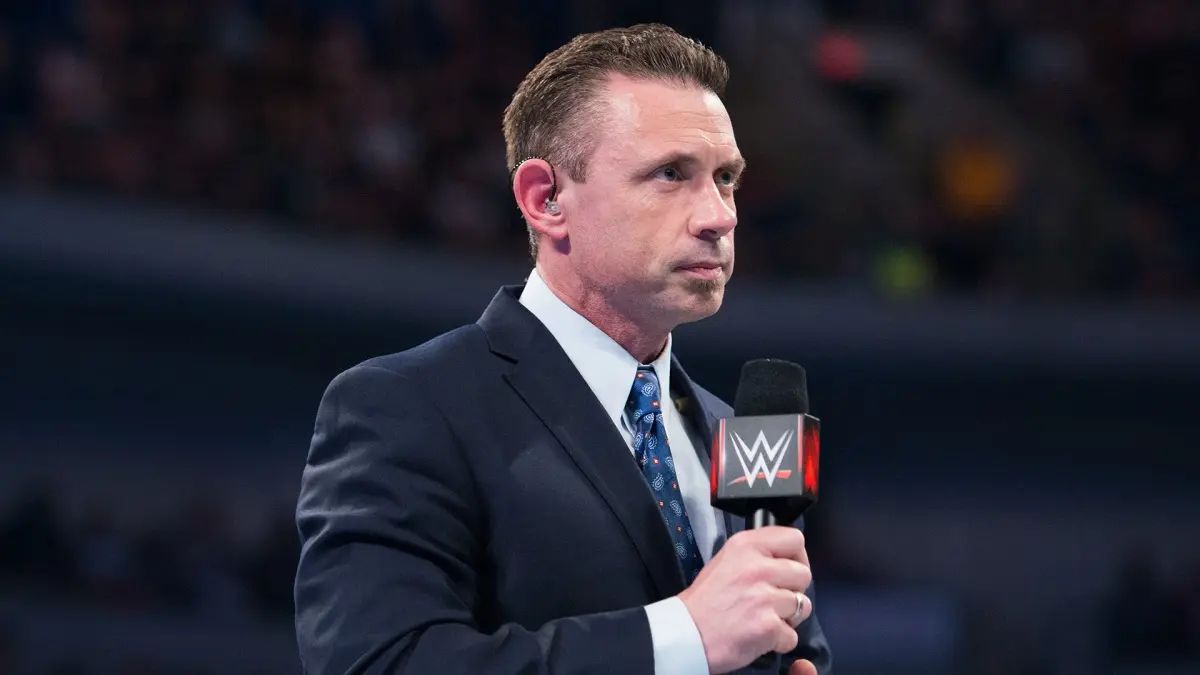 Michael Cole with a microphone and an earpiece