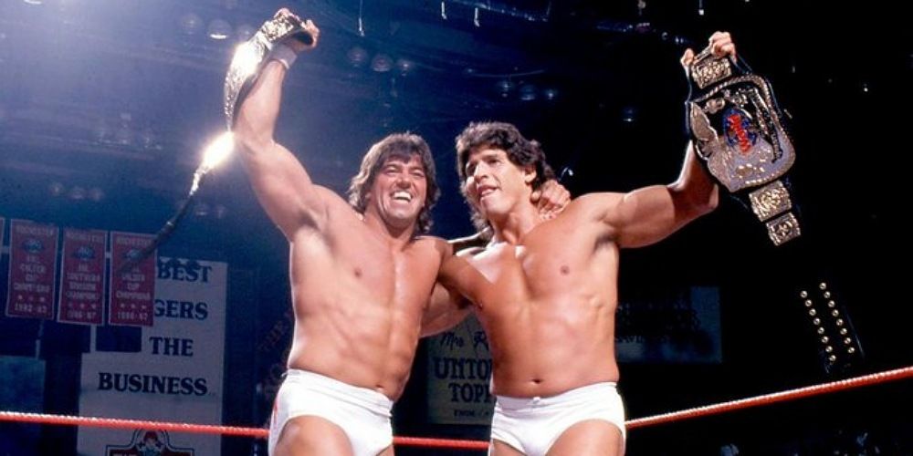 Strike Force holding up the WWE Tag Team Championships. 