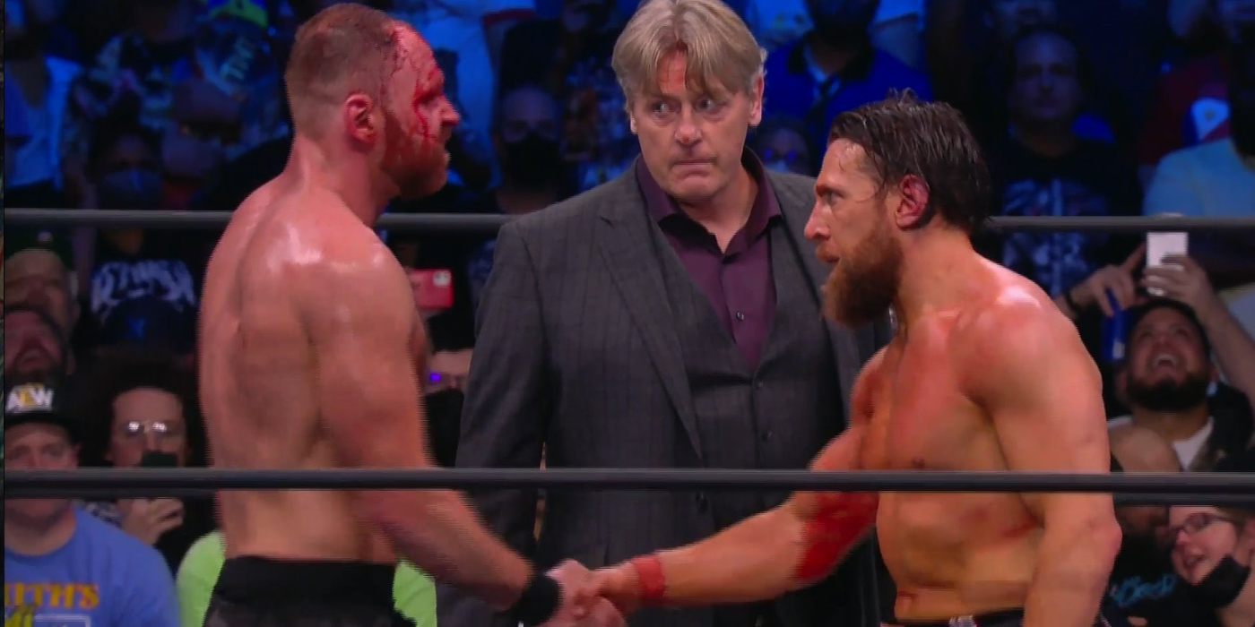 Jon Moxley with William Regal and Bryan Danielson in the ring at AEW Revolution 2022