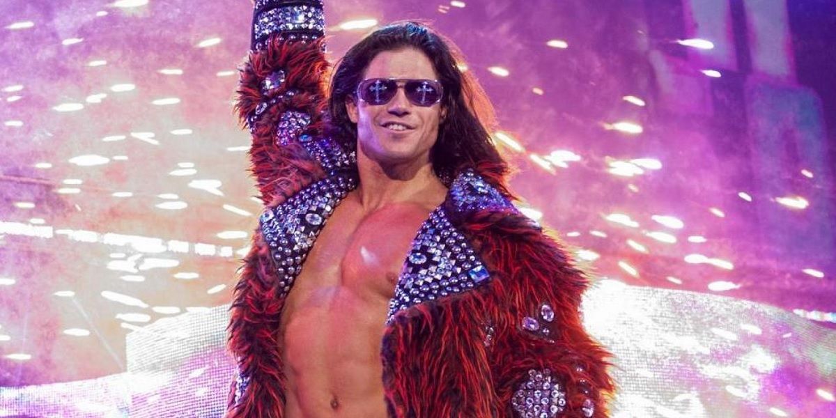 John Morrison posing while pyrotechnics go off behind him