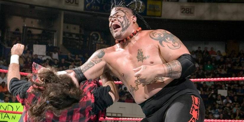 Umaga clotheslines Mick Foley.