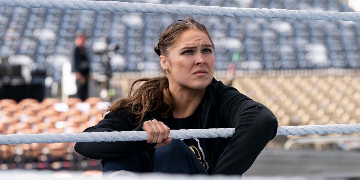 Ronda Rousey sat on the ring apron 