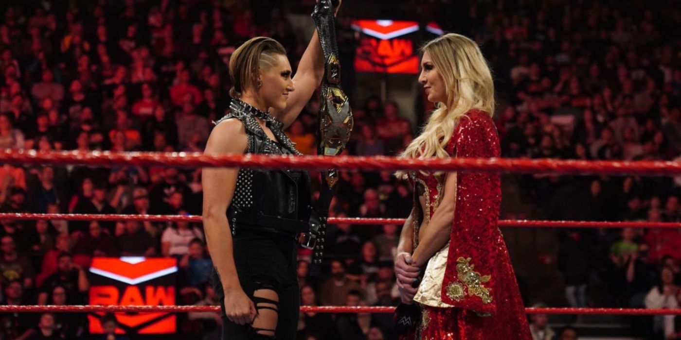 rhea ripley showing the nxt women's title to charlotte flair