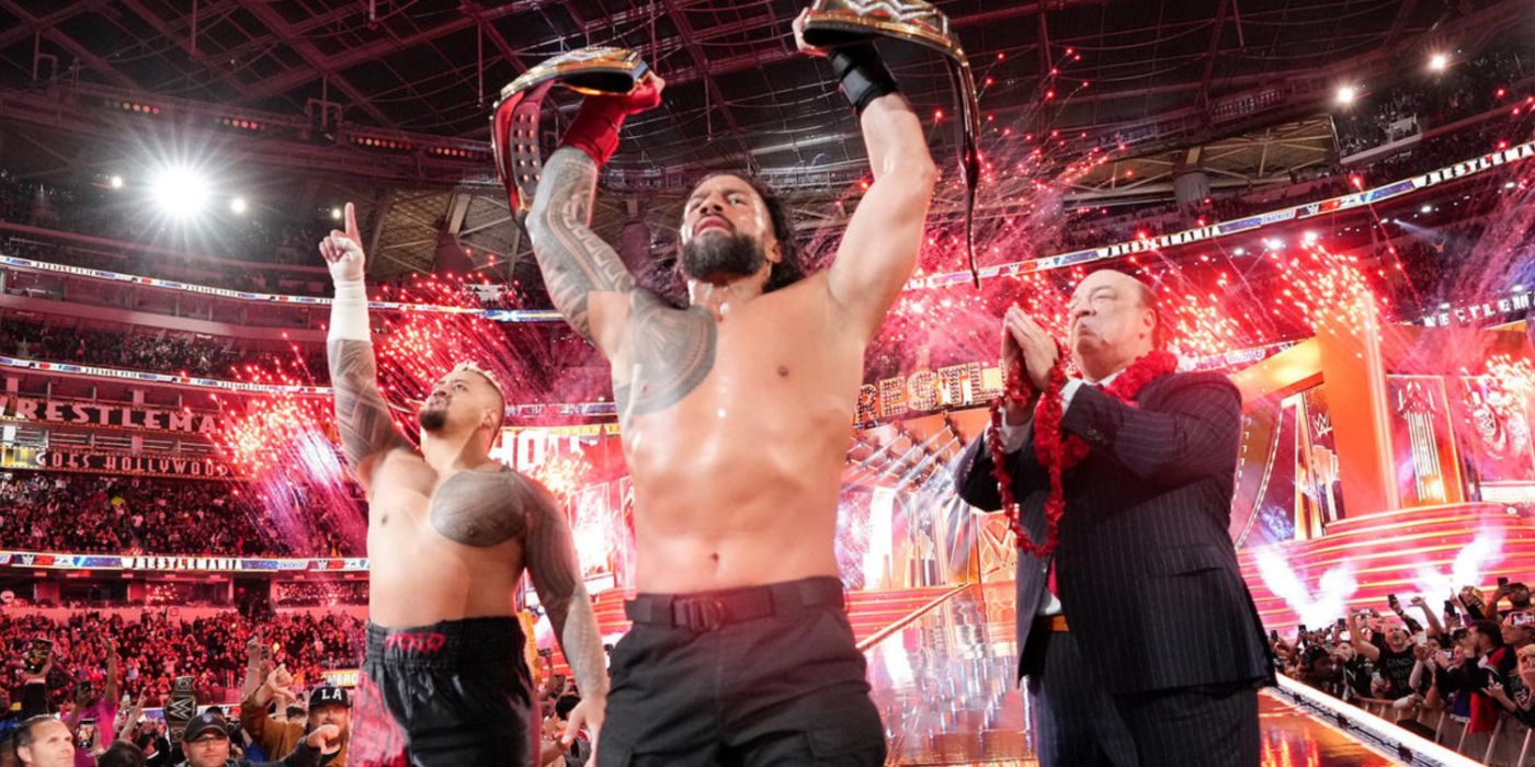 roman reigns lifting the titles with solo sikoa and paul heyman at wrestlemania