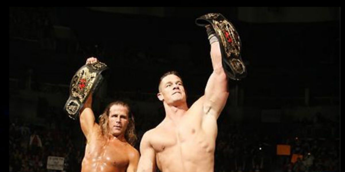 John Cena and Shawn Michaels holding up the World Tag Team Championships. 