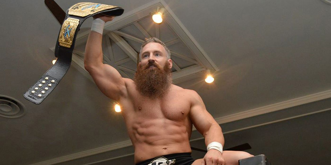 Matt Cross with a title belt.
