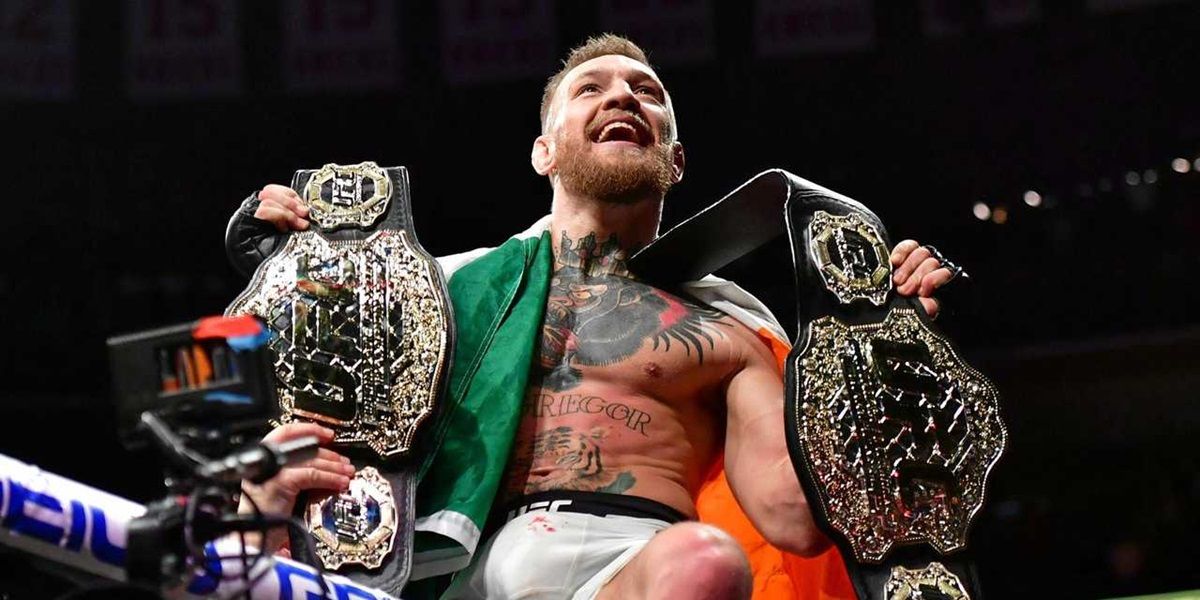 Conor McGregor holds up two UFC belts