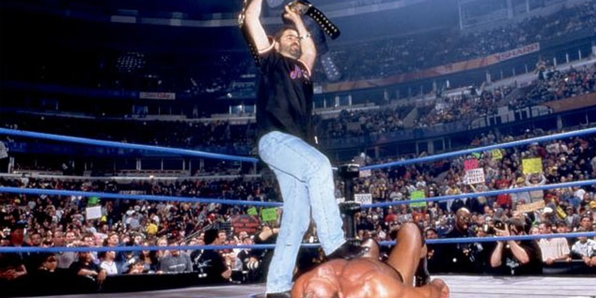 Vince Russo stands on top of a fallen wrestler.
