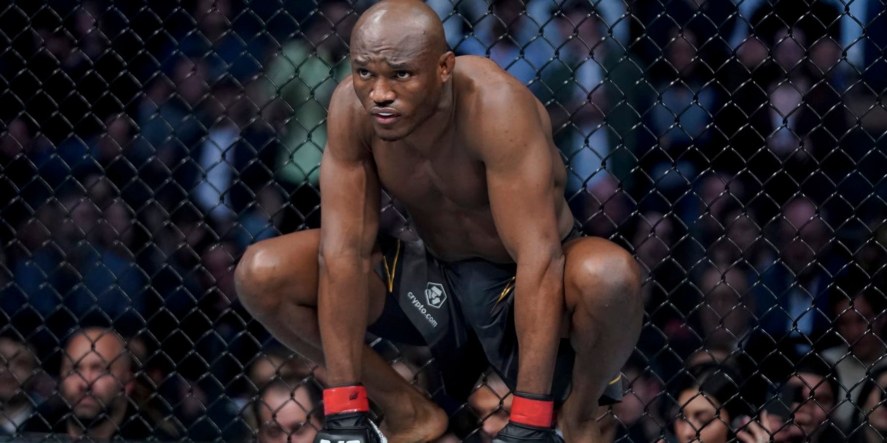 Kamaru Usman kneels in the UFC octagon