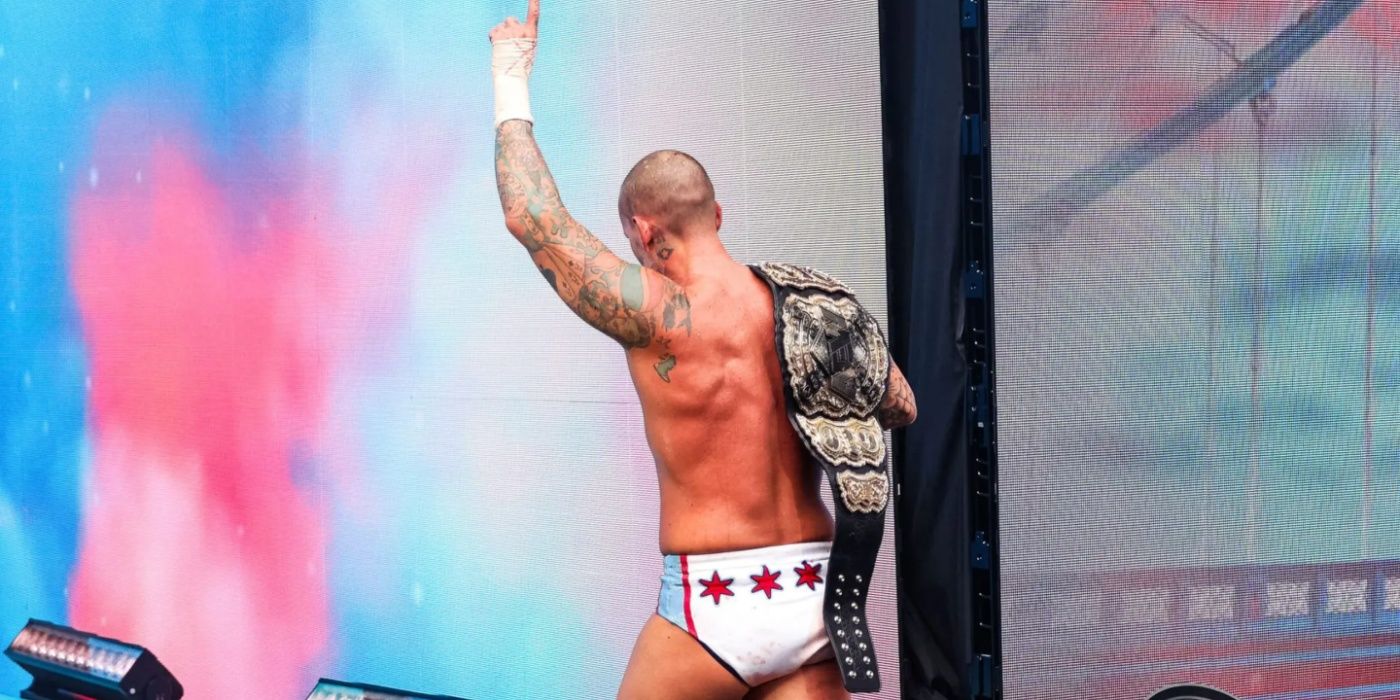 Cm punk leaving the ring with his title and his hand raised in AW