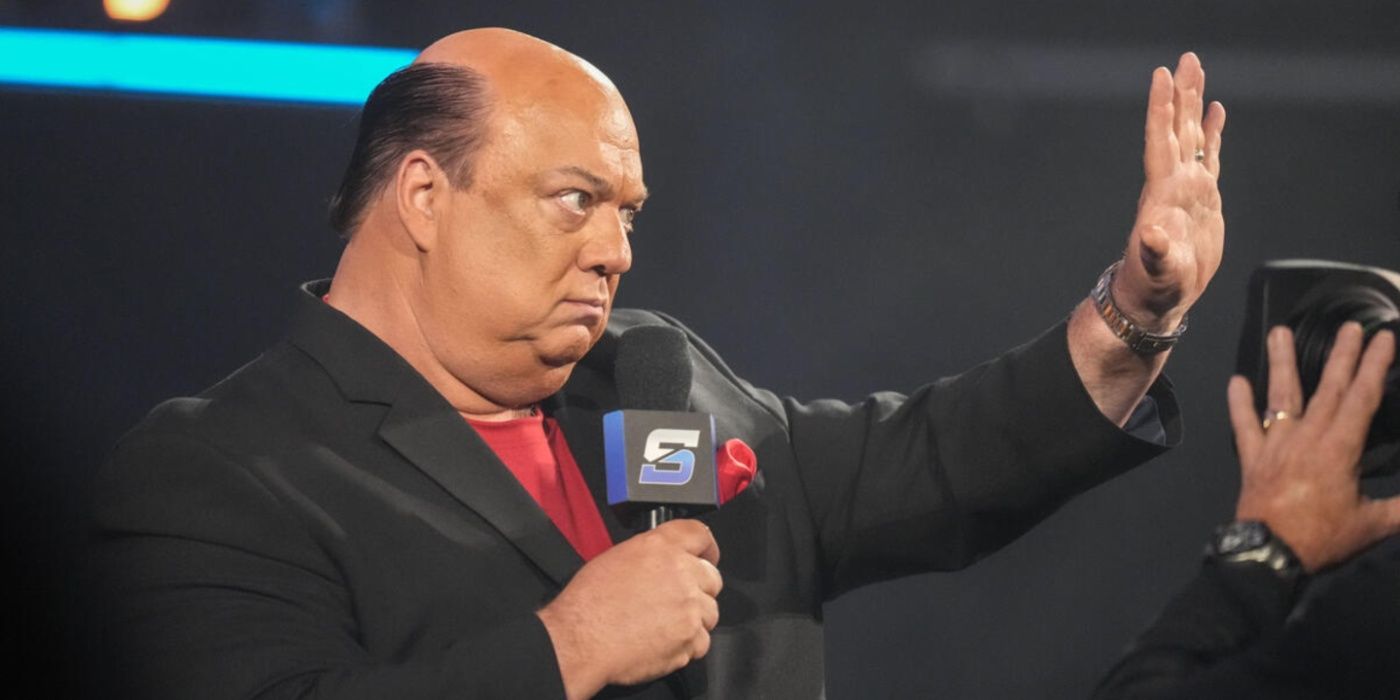 paul heyman holding up his hand.