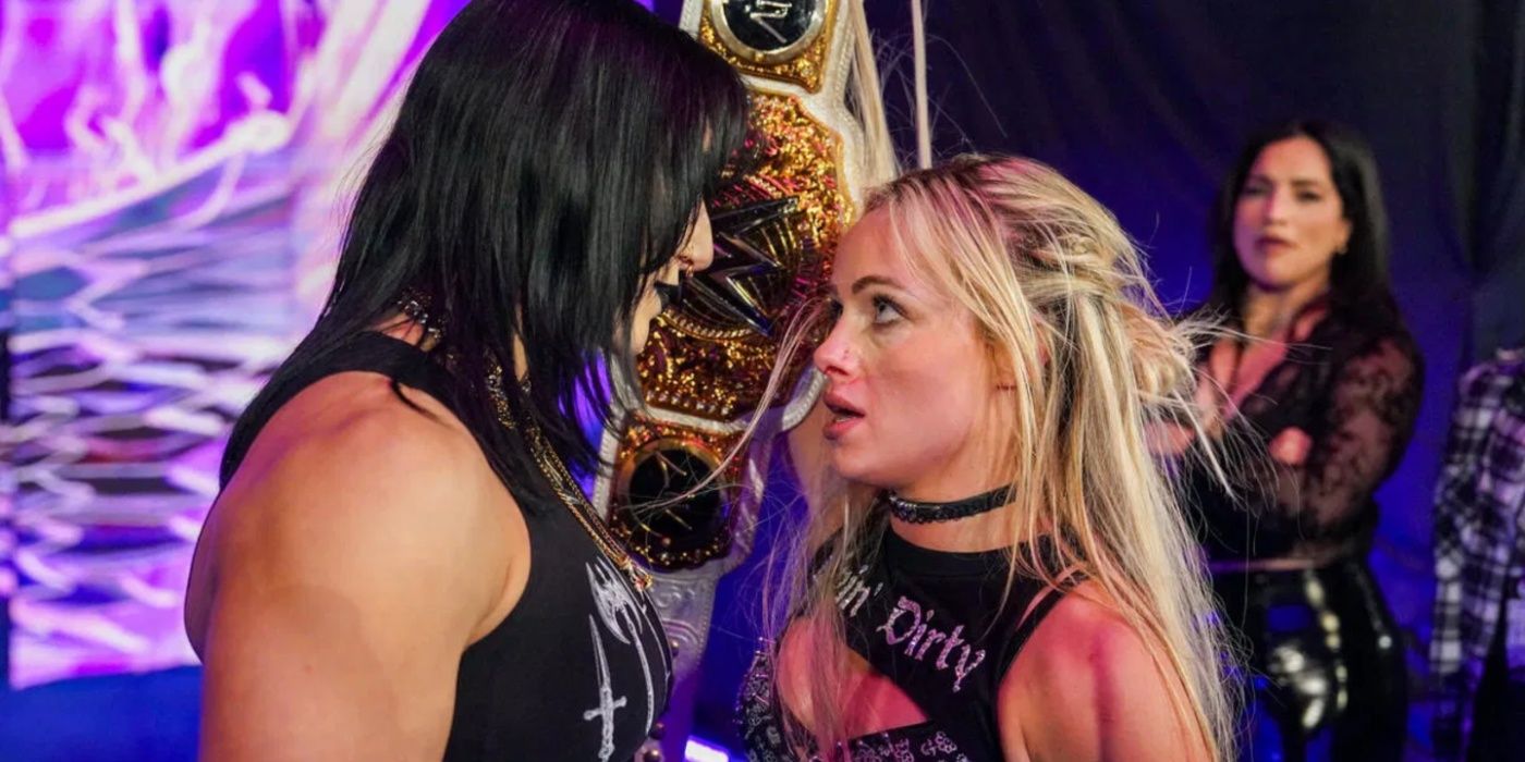 liv morgan holding up her title to rhea ripley.