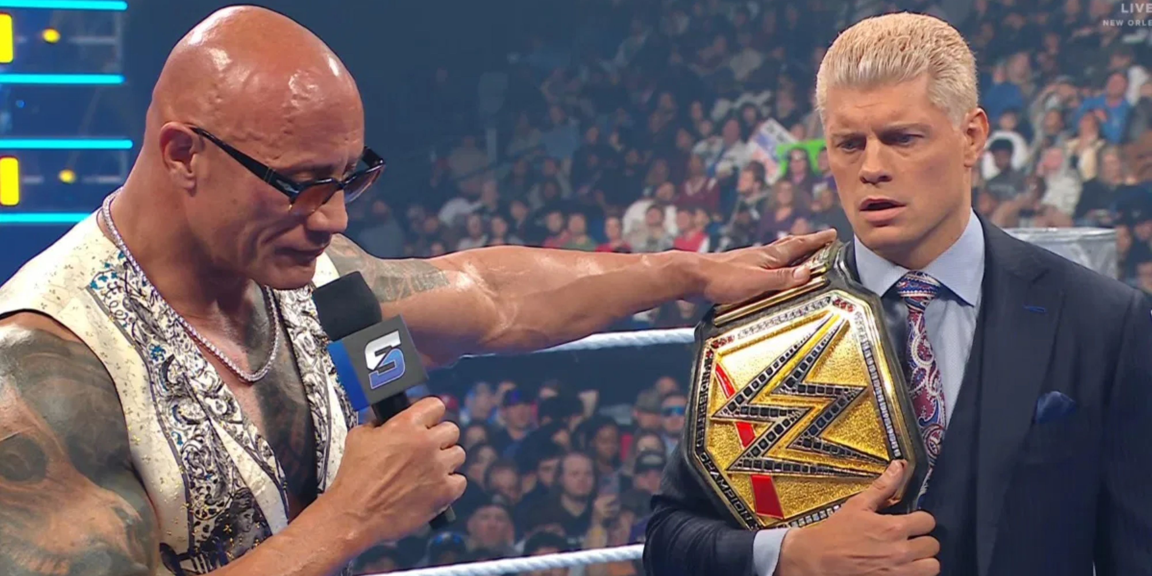 The rock with his hand on the shoulder of Cody Rhodes.