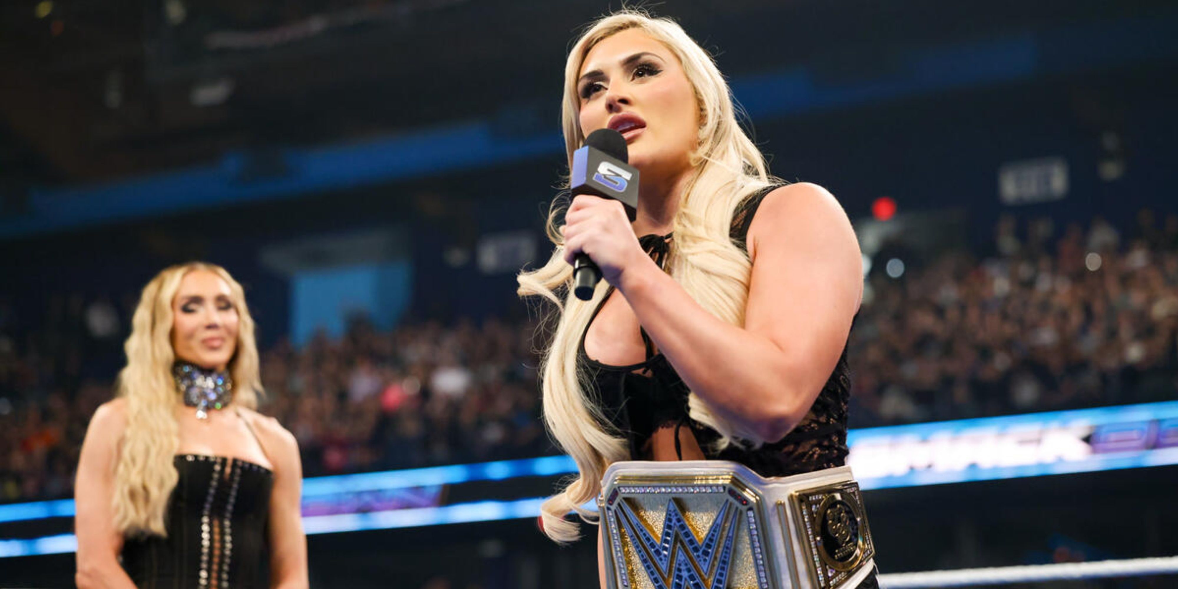 tiffany stratton cutting a promo with charlotte flair behind her.