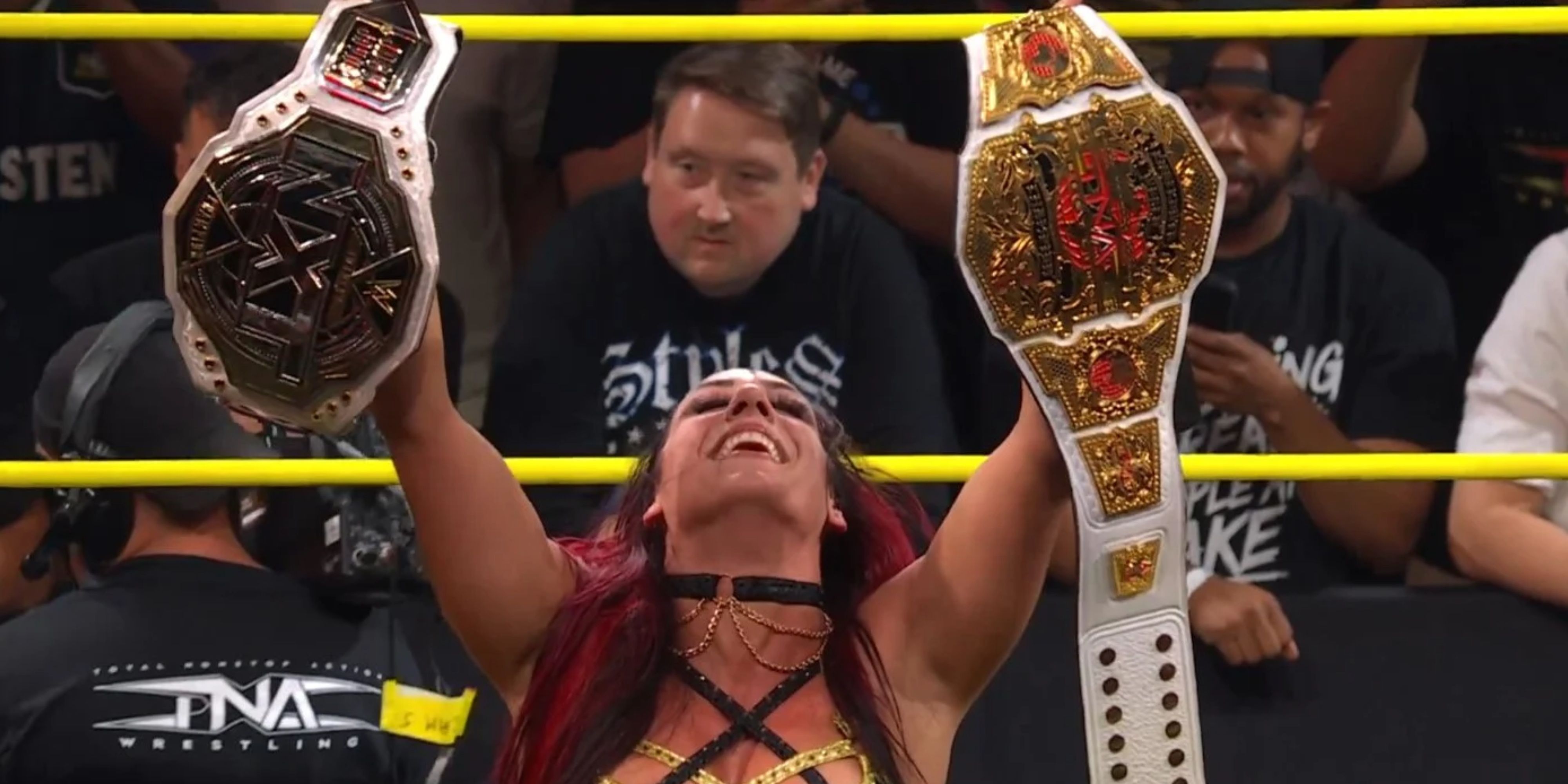 jacy jayne holding up the nxt and tna knockouts titles.