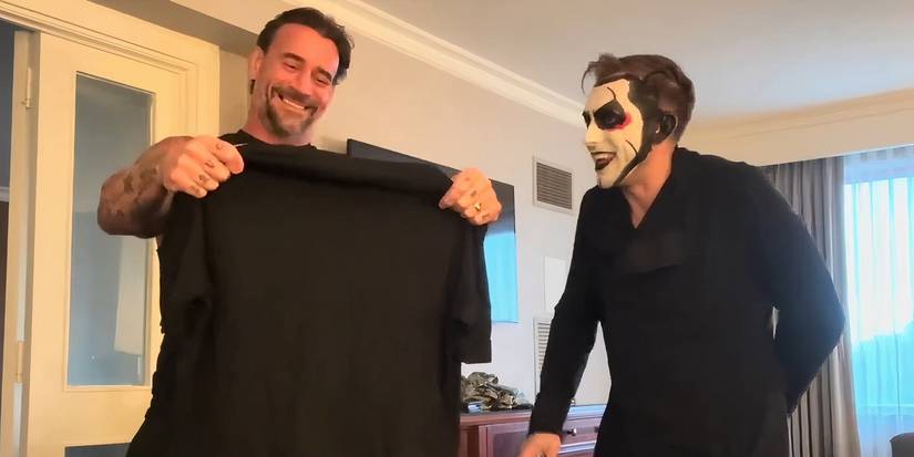 Danhausen giving CM Punk a t-shirt that makes both of them smile