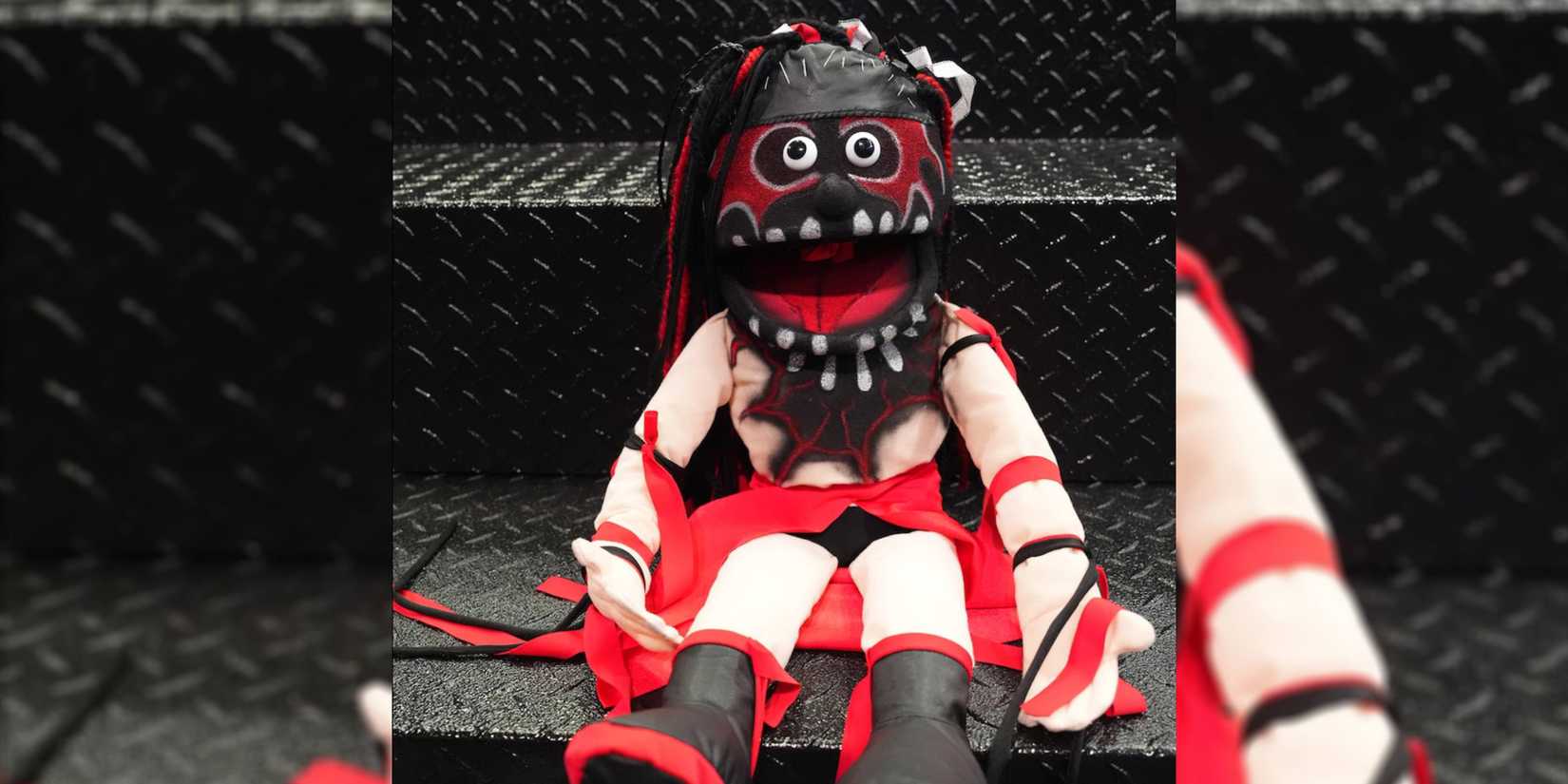 finn balor demonito puppet sitting on steel steps.